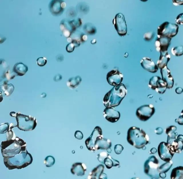 Close-up of suspended water droplets representing water-based adhesive dispersion.