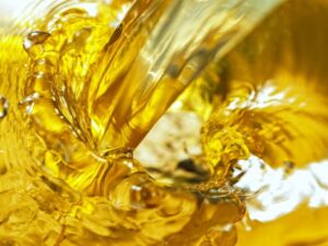 High-viscosity rubber-based adhesive being poured, creating golden swirls and ripples—used in industrial and commercial bonding applications.Let me know if you need a blog introduction or accompanying SEO-friendly text as w